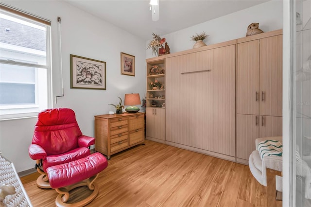 living area with a wealth of natural light and light hardwood / wood-style flooring