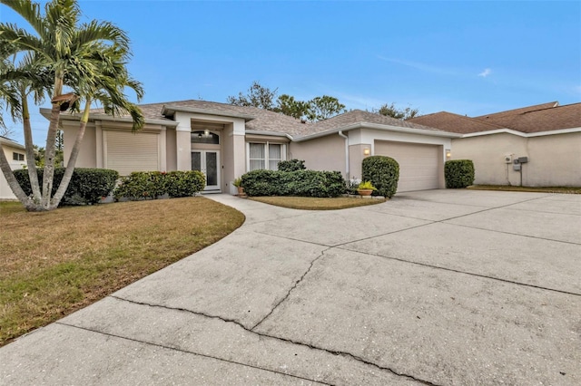 single story home with a garage and a front lawn