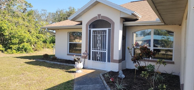 view of exterior entry with a lawn