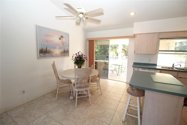 tiled dining area featuring sink, ceiling fan, and vaulted ceiling