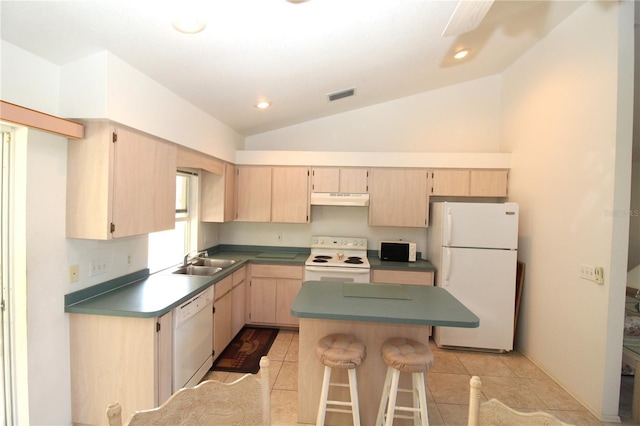 kitchen featuring white appliances, a kitchen breakfast bar, vaulted ceiling, light brown cabinetry, and sink