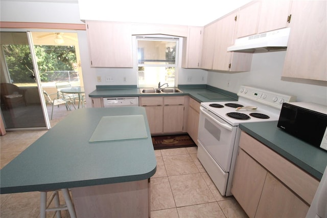 kitchen with sink, light brown cabinets, white appliances, light tile patterned flooring, and a kitchen island