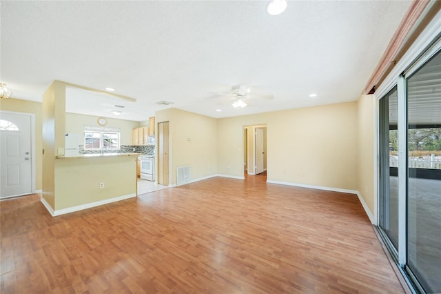 unfurnished living room featuring light wood-type flooring and ceiling fan