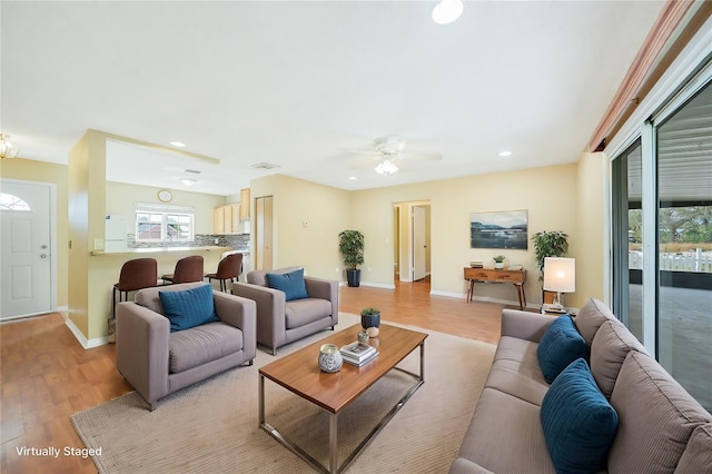 living room with ceiling fan and light wood-type flooring