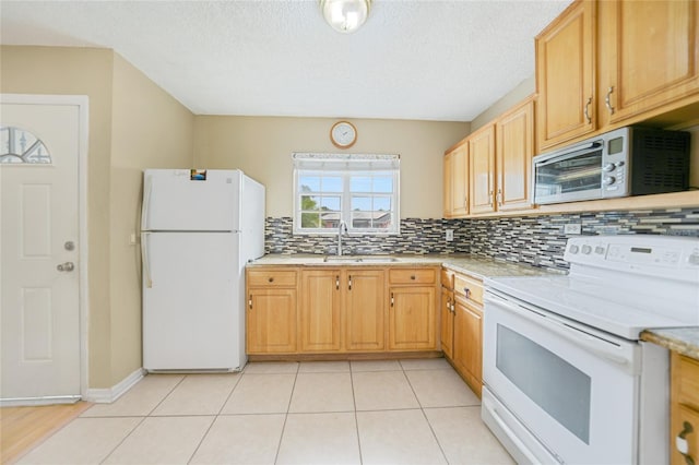 kitchen featuring white appliances, light brown cabinetry, light tile patterned floors, decorative backsplash, and sink