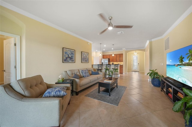 living room with ceiling fan, light tile patterned floors, and crown molding