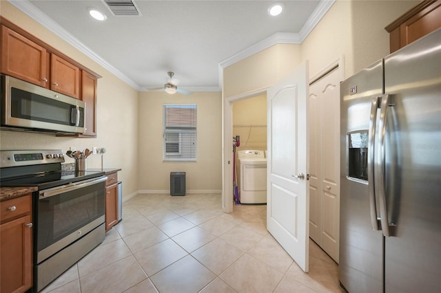 kitchen featuring crown molding, ceiling fan, appliances with stainless steel finishes, light tile patterned flooring, and washer / clothes dryer