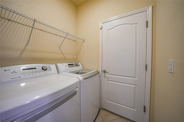 laundry area featuring light tile patterned floors and washing machine and clothes dryer