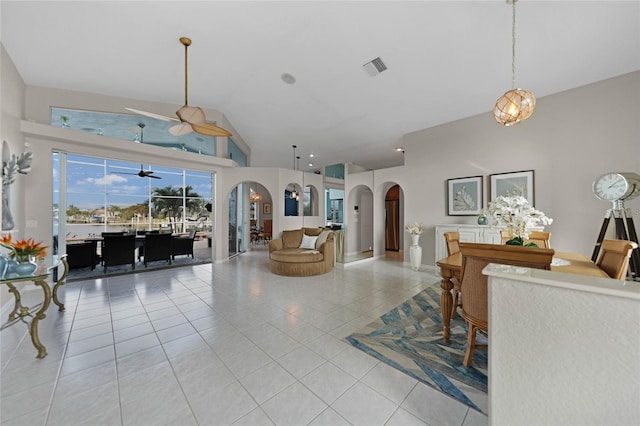 tiled living room with ceiling fan and vaulted ceiling