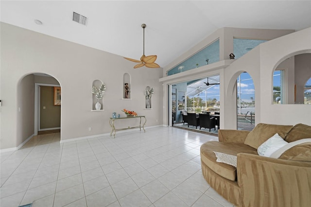 living room featuring ceiling fan, vaulted ceiling, and light tile patterned flooring