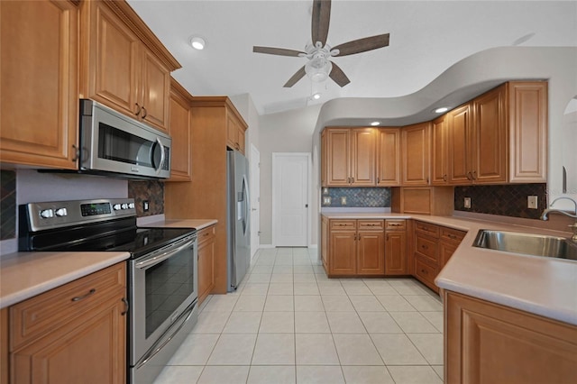 kitchen featuring light tile patterned floors, backsplash, sink, and stainless steel appliances