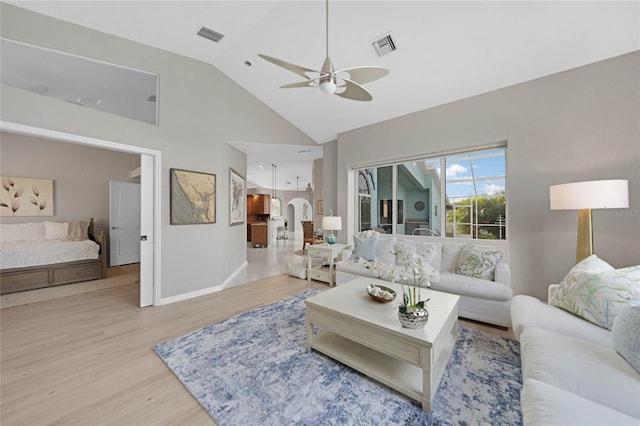 living room featuring ceiling fan, high vaulted ceiling, and light wood-type flooring