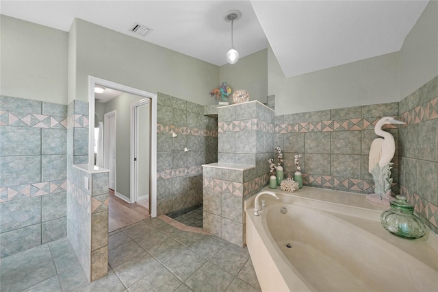 bathroom featuring independent shower and bath, tile walls, and tile patterned floors