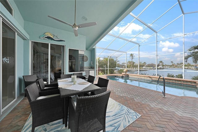 view of patio with ceiling fan, glass enclosure, and a water view