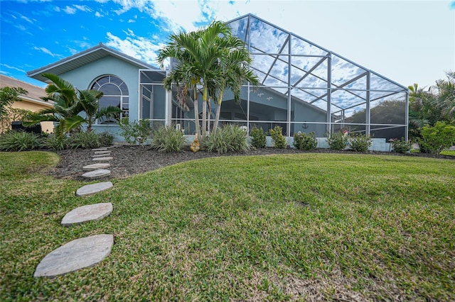 rear view of property featuring a lanai and a yard