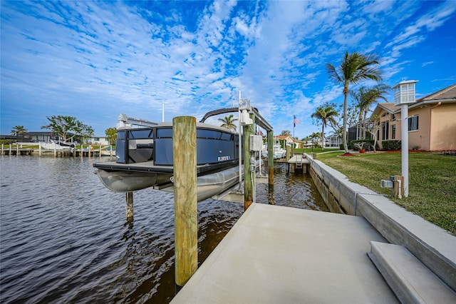 view of dock with a yard and a water view