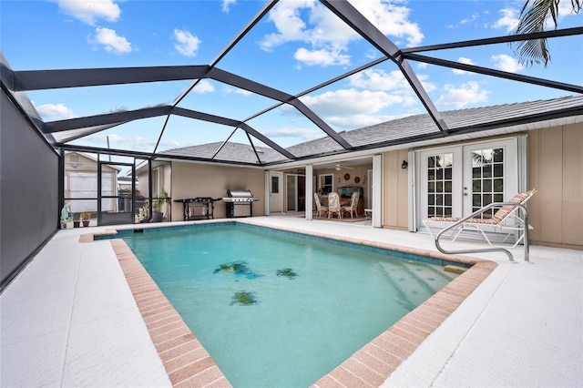 view of swimming pool featuring glass enclosure, a grill, a patio area, area for grilling, and french doors