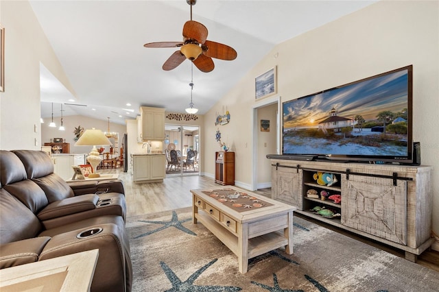 living room featuring lofted ceiling, ceiling fan, recessed lighting, baseboards, and light wood finished floors