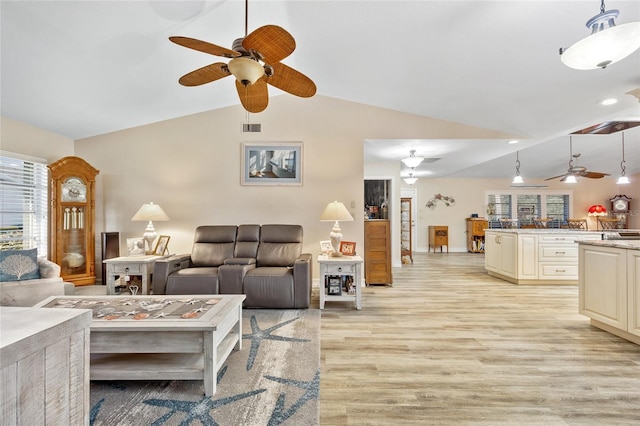 living room featuring light hardwood / wood-style flooring, vaulted ceiling, and ceiling fan