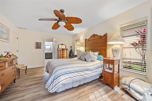 bedroom with ceiling fan, ensuite bath, and wood-type flooring