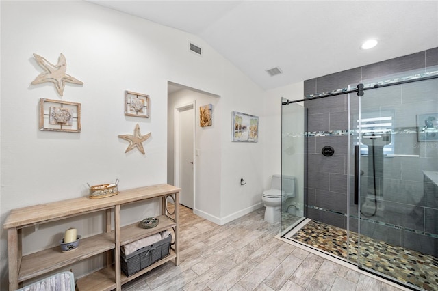 bathroom featuring toilet, a shower with shower door, and vaulted ceiling