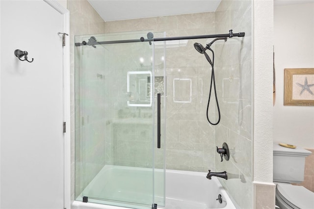 bathroom with toilet and combined bath / shower with glass door