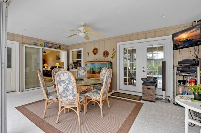 tiled dining room with ceiling fan and french doors