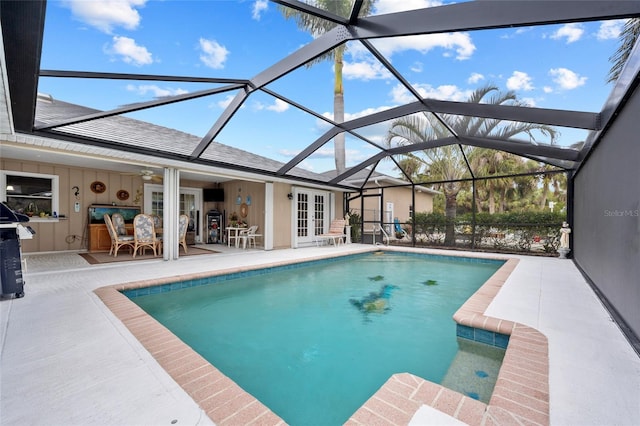 pool with glass enclosure, french doors, a patio area, and ceiling fan