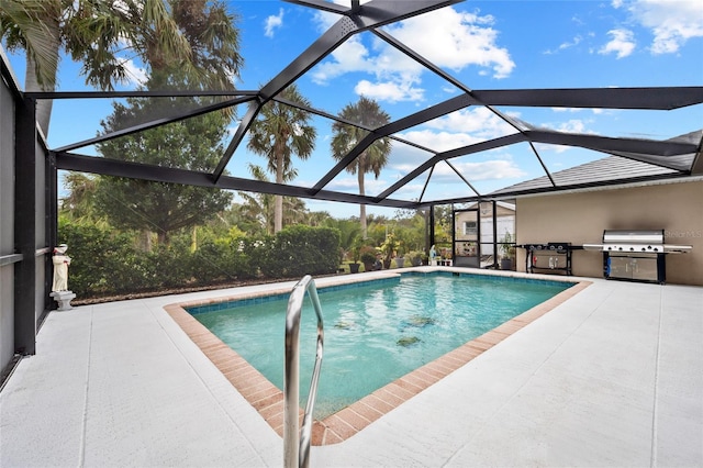 view of swimming pool with exterior kitchen, area for grilling, glass enclosure, and a patio area