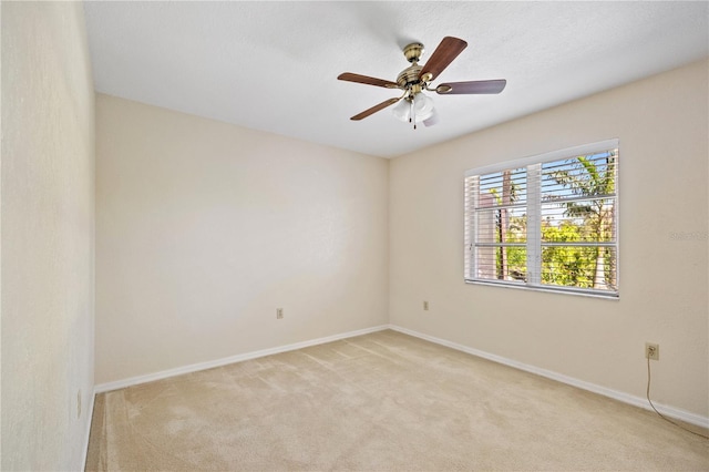 empty room featuring light carpet, ceiling fan, and baseboards