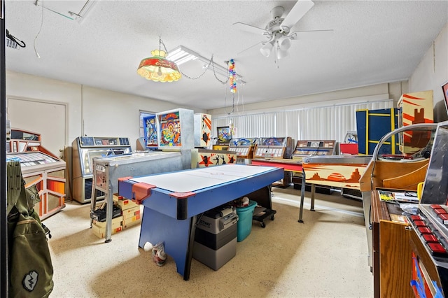 playroom featuring ceiling fan, a textured ceiling, and speckled floor