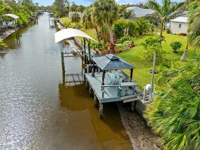 view of dock with a yard, a water view, and boat lift