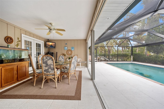 exterior space featuring a ceiling fan, glass enclosure, french doors, a patio area, and outdoor dining space