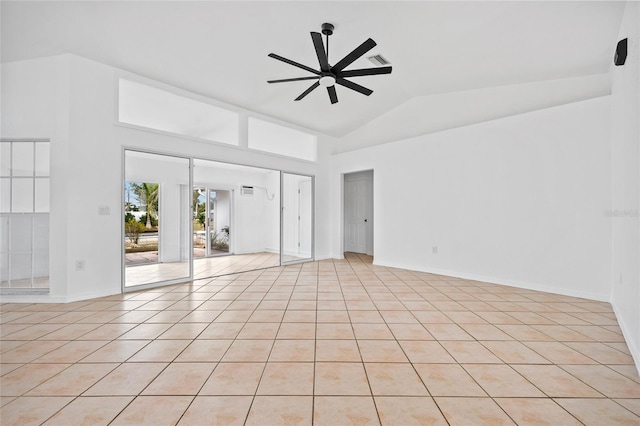 spare room featuring lofted ceiling, ceiling fan, and light tile patterned flooring