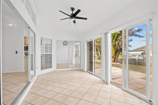 unfurnished sunroom with ceiling fan