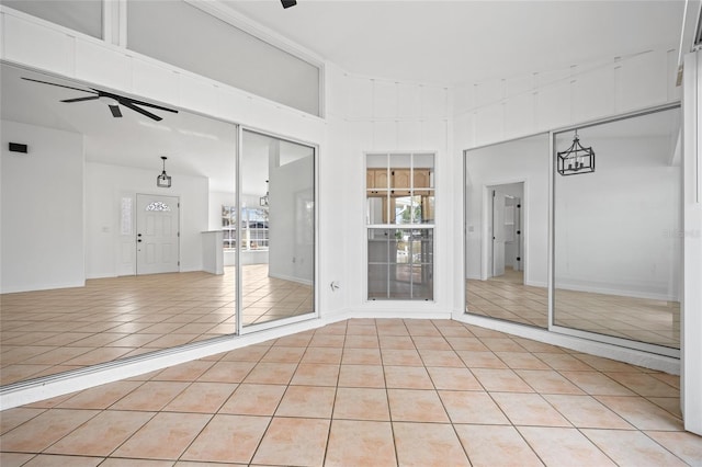 empty room featuring ceiling fan and light tile patterned floors