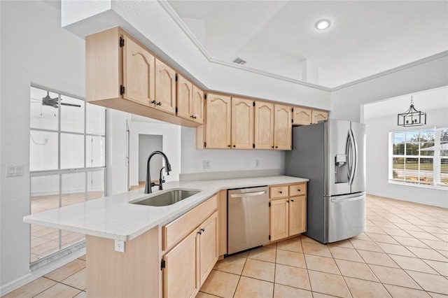 kitchen with kitchen peninsula, sink, appliances with stainless steel finishes, light tile patterned floors, and light brown cabinetry