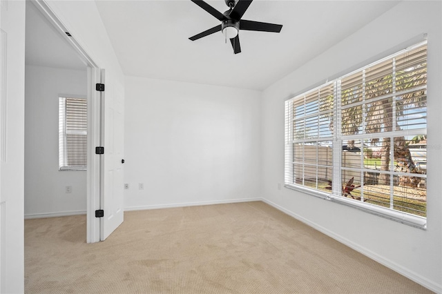 spare room featuring light carpet and ceiling fan