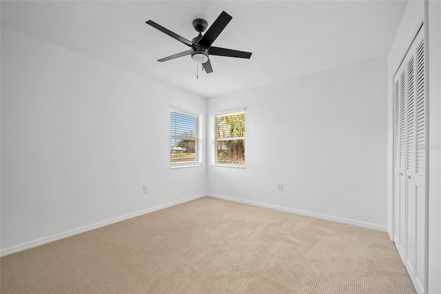 unfurnished bedroom with ceiling fan, light colored carpet, and a closet