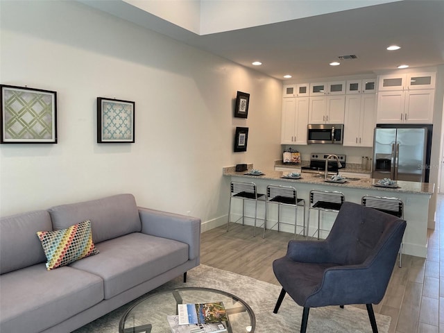 living room with sink and light hardwood / wood-style flooring