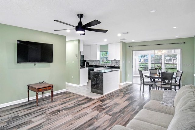 living room featuring hardwood / wood-style floors, ceiling fan, and sink