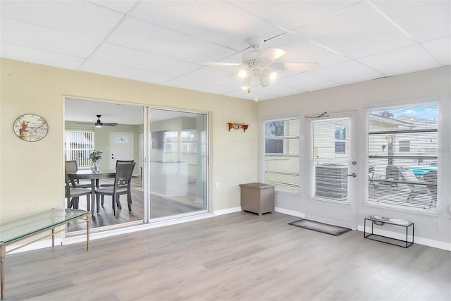 sunroom / solarium featuring a drop ceiling, a healthy amount of sunlight, and ceiling fan