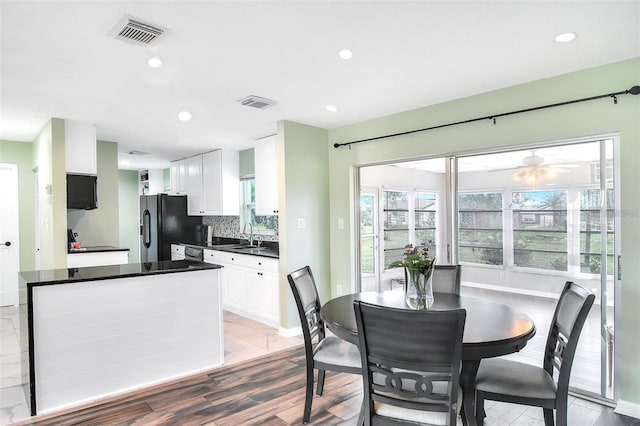 dining room featuring ceiling fan, sink, and light hardwood / wood-style flooring