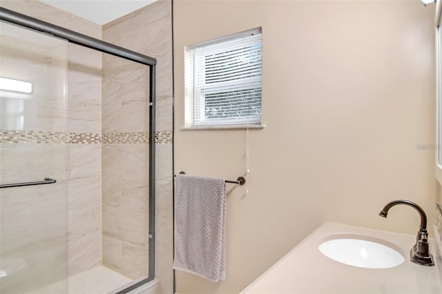 bathroom featuring an enclosed shower and sink