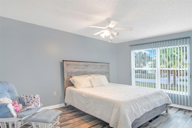 bedroom featuring ceiling fan, wood-type flooring, and a textured ceiling