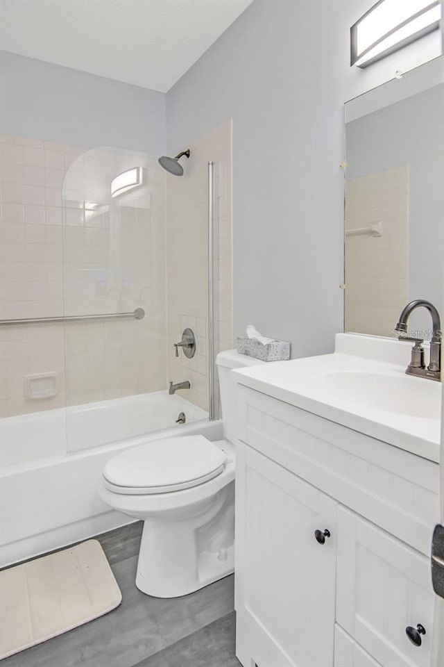 full bathroom featuring vanity, tiled shower / bath combo, and toilet