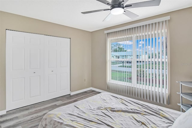 bedroom featuring hardwood / wood-style floors, ceiling fan, and a closet