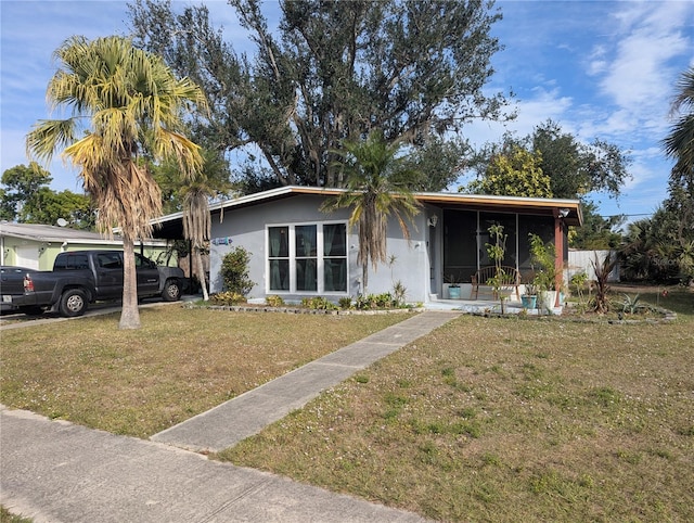 view of front of property with a front yard and a carport