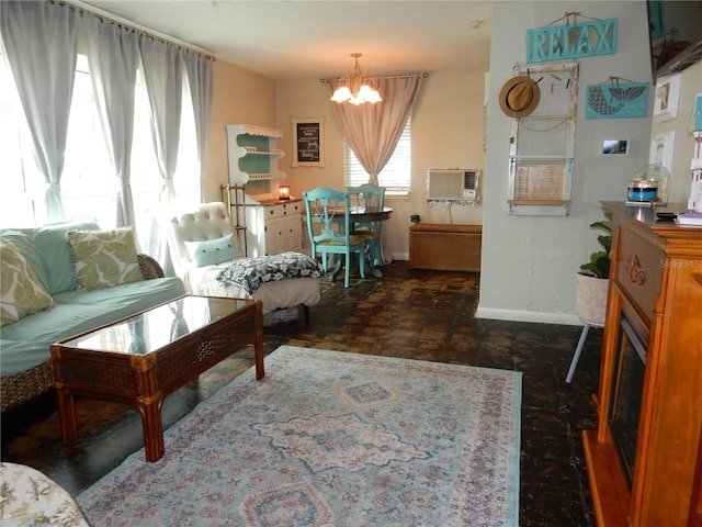 living room with a wall unit AC and a notable chandelier