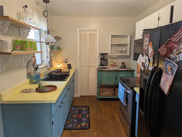 kitchen with sink, white cabinets, black fridge, hanging light fixtures, and stainless steel range with electric stovetop